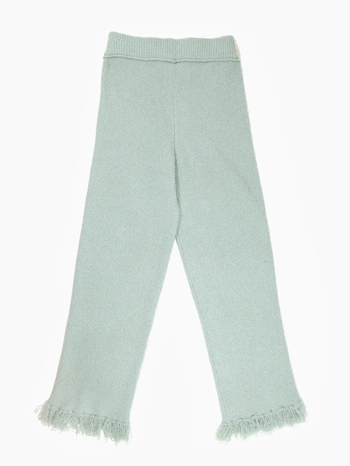 A pair of Hoki Pants Green by Rus with a ribbed waist and fringed hems, available at Bassalstore in Barcelona. The pants also feature vertical knitted seams along the legs.