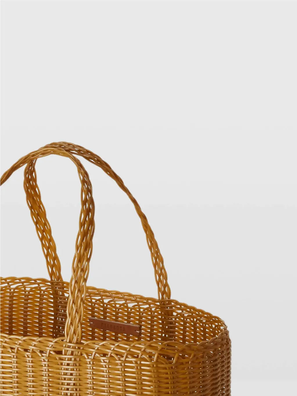 A tan woven straw tote bag, Lace Small Bag Tobacco by Palorosa, with a rectangular shape and two matching handles, available at bassalstore. The bag features an open, airy weave design and is displayed on a simple white background.