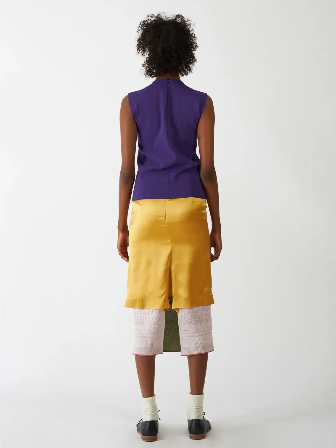 A sleeveless, dark purple top called the Neru Top Purple from Bielo is displayed on a plain white background from Bassalstore Barcelona. The top has a simple, straight cut with a high neckline and a zipper at the back.