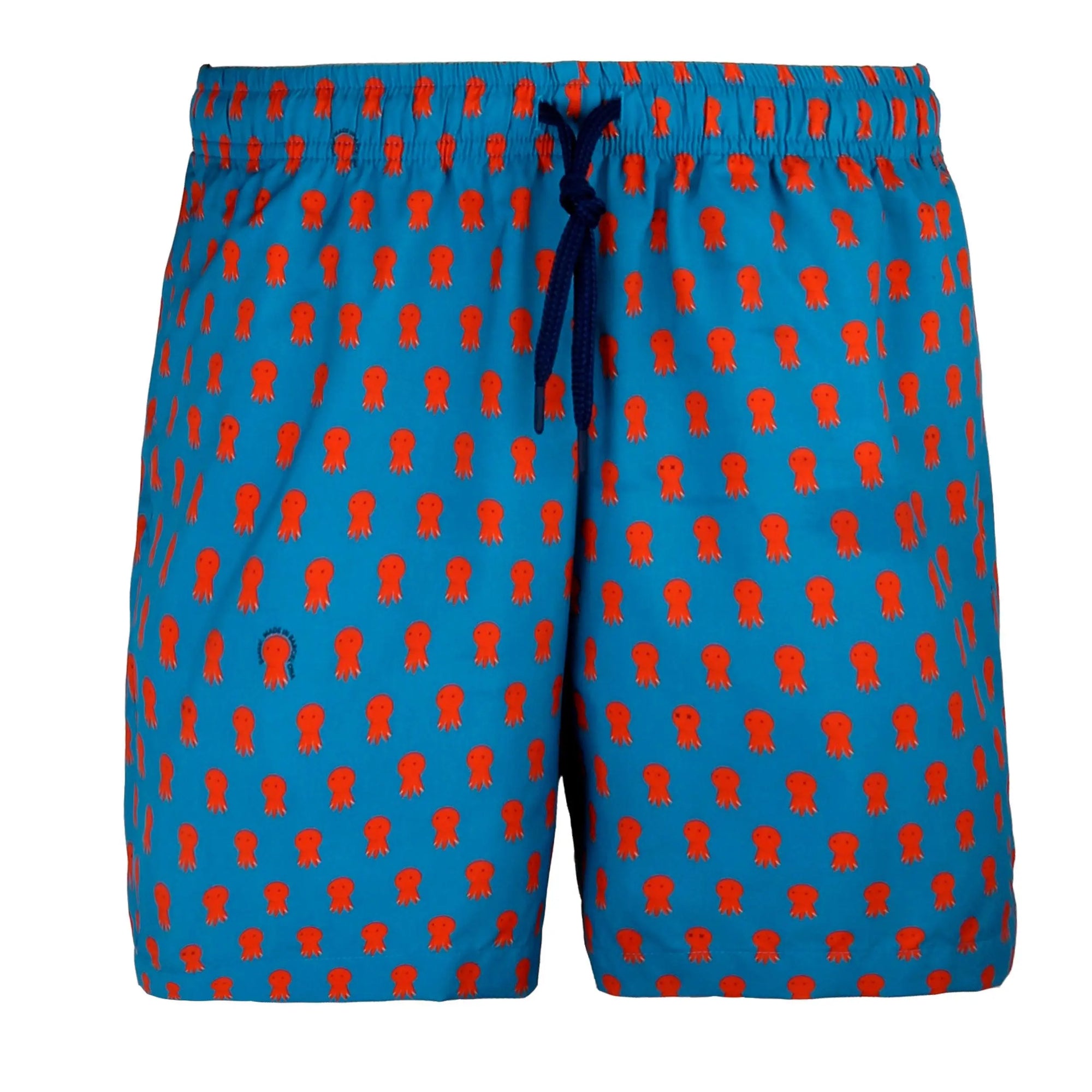 A neatly packed pair of Octo Swimwear with an orange octopus pattern is displayed in an open white box. The waistband is elastic with a blue drawstring. A tag labeled "Bassal" is attached to the swimwear, which are folded and arranged tidily inside the box.
