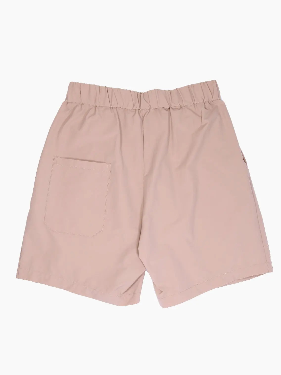 A pair of blush pink shorts with an elastic waistband and pleated front. The shorts are made from a light, flowy fabric and have a relaxed fit, perfect for casual wear. Discover Mundaka's Oversized Bermuda Beige at our Barcelona store for a chic addition to your wardrobe.