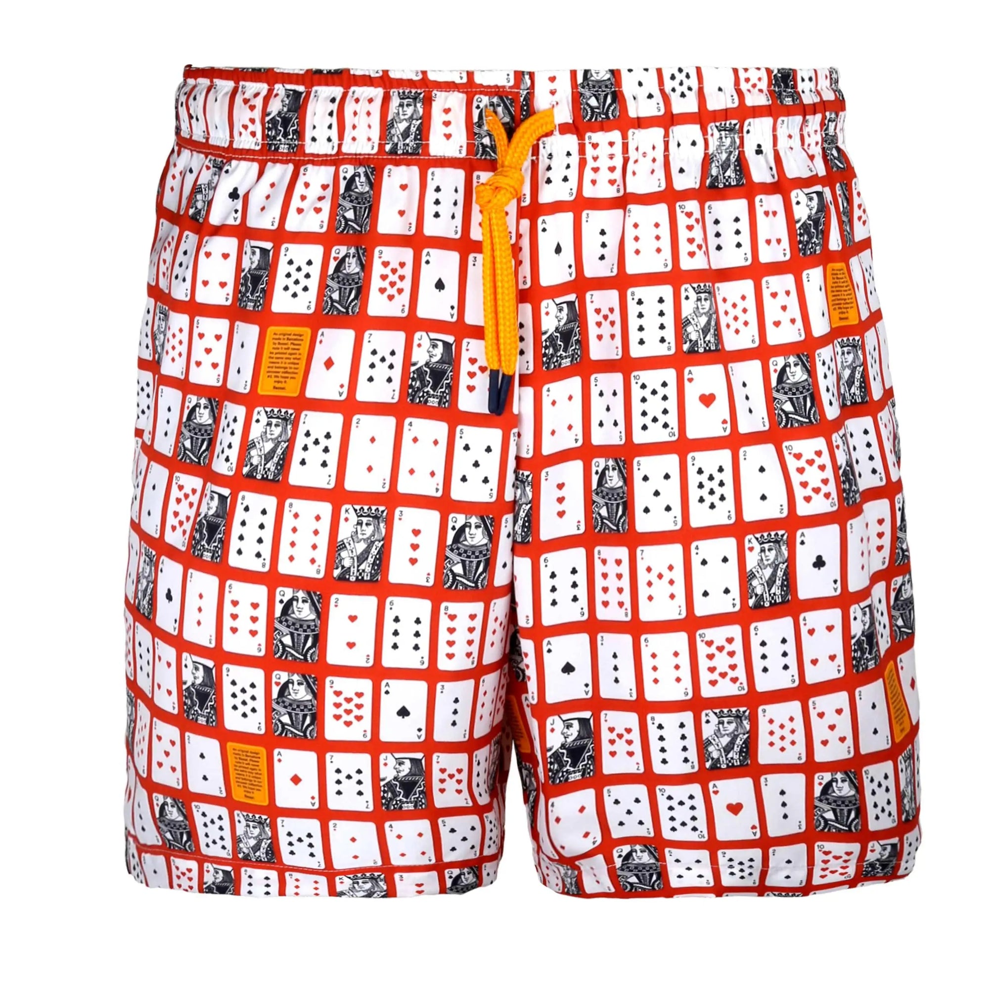 A small white box with a lid partially removed reveals a fabric bag inside. The bag, boasting a colorful playing card pattern and an orange drawstring, is from the Bassal. store in Barcelona. Attached to the bag are two tags—one blue and one white—with text including "Poker Swimwear".