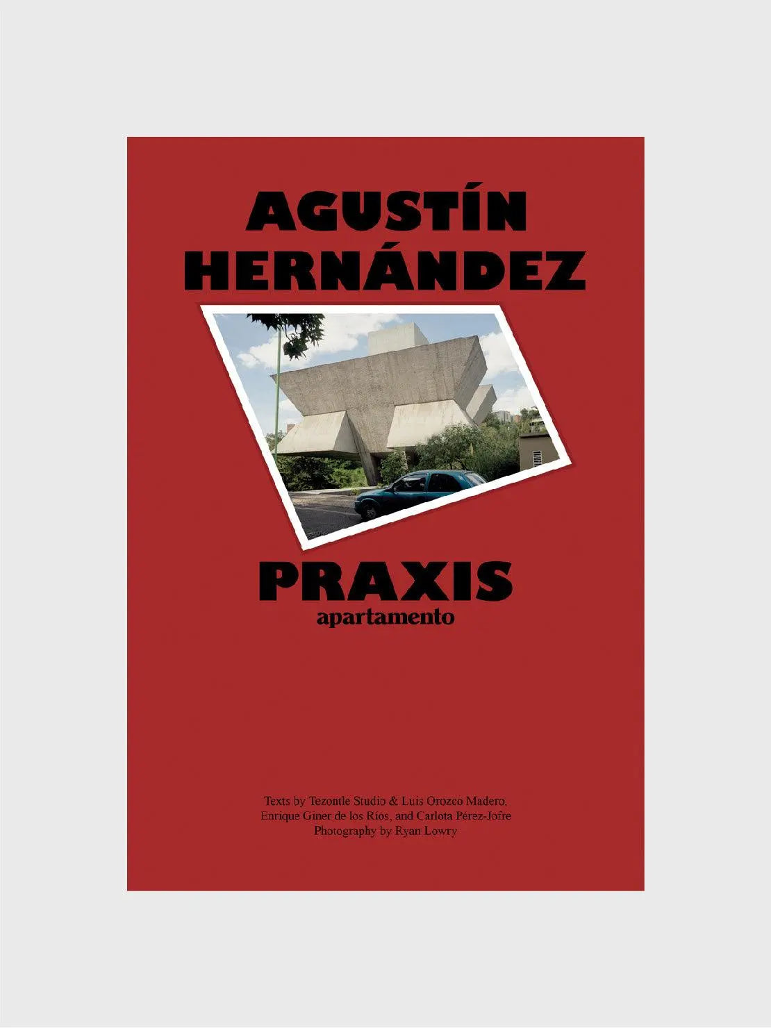 A red book cover features large black text that reads "Agustín Hernández" at the top and "Praxis" in the middle. Below the title is a photograph of a uniquely designed, modernist building in Barcelona. The authors and photographer's names are listed at the bottom, available at Bassalstore from Apartamento.