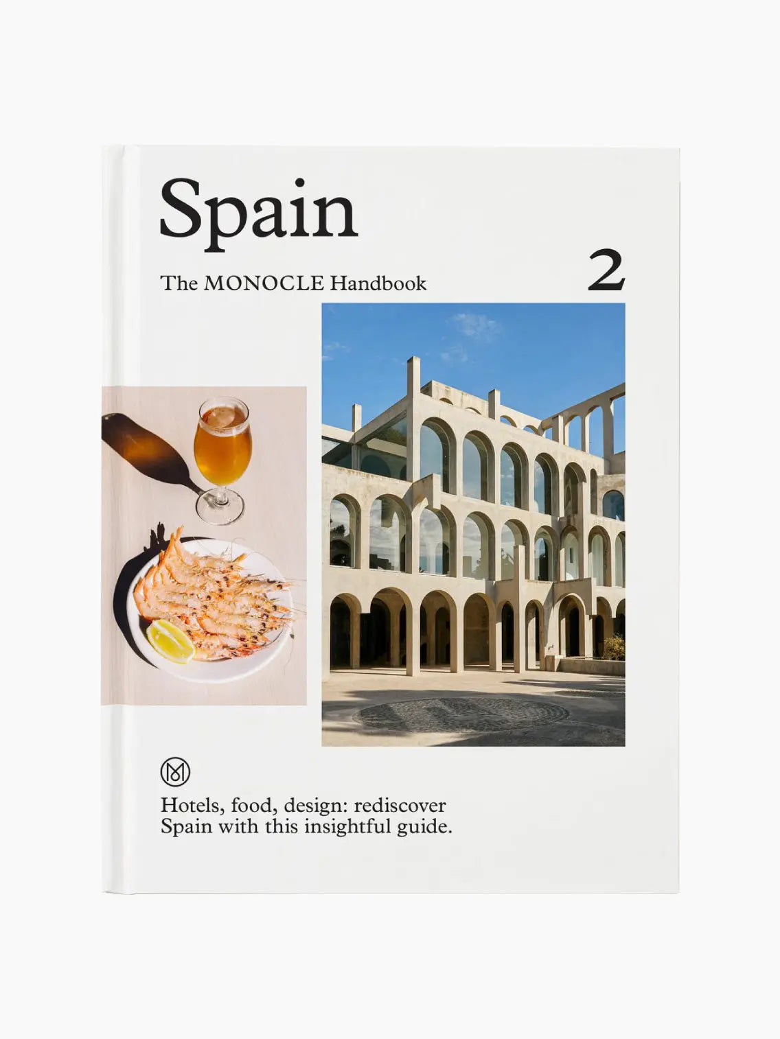 The cover of "Spain: The Monocle Handbook" showcases a modern architectural building in Barcelona with arches and a plate of shrimp paired with a glass of beer. Text on the cover reads, "Hotels, food, design: rediscover Spain with this insightful guide from Monocle.