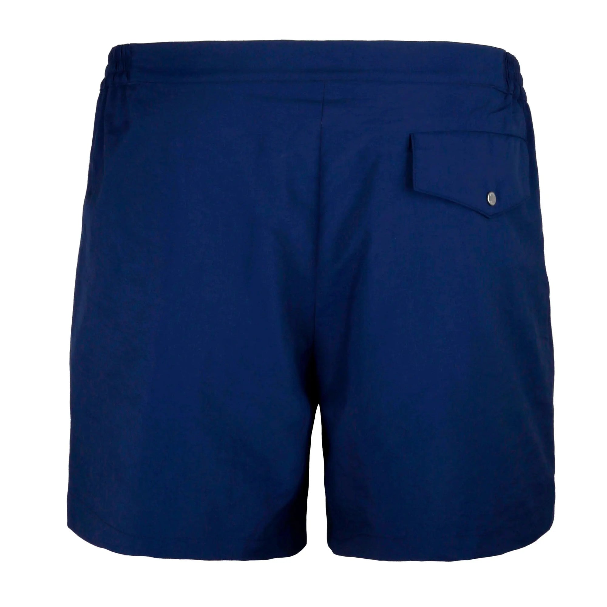 A neatly folded dark blue bermuda swimwear is placed in a white box with a brown interior. The box lid, slightly off to the side, and a tag on the swimwear both feature the brand name "Bassal." A small plastic packet is attached to the tag. Discover this elegant piece exclusively at BassalStore, your go-to for Barcelona style.
